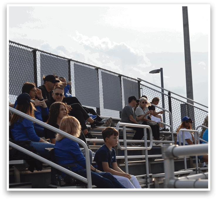 A group of people are sitting on a bleacher at a baseball game. AI generated content