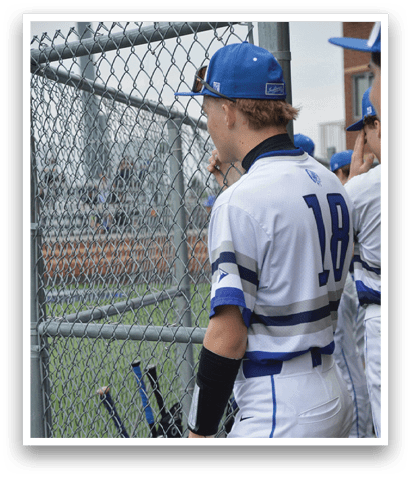 A baseball player wearing a blue hat and a white jersey is sitting on a bench. AI generated content