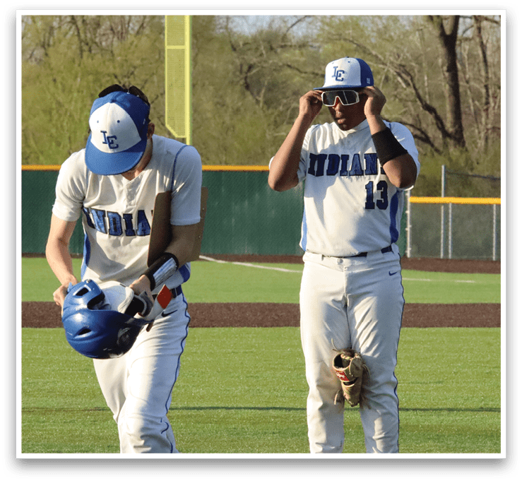 Two baseball players wearing white uniforms and blue caps are walking on a field. One player is holding a baseball glove. AI generated content