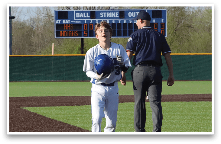 A boy wearing a baseball uniform walks past an umpire on a baseball field. AI generated content