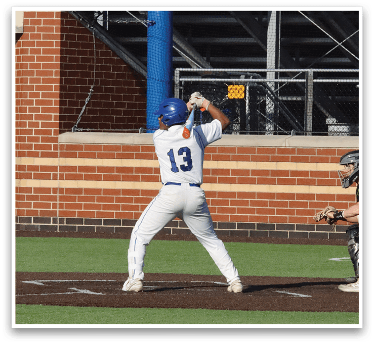 A baseball player in a white uniform is swinging a bat, attempting to hit a ball. The player is wearing a helmet for protection. The scene takes place on a baseball field, with a crowd of spectators watching the game. AI generated content