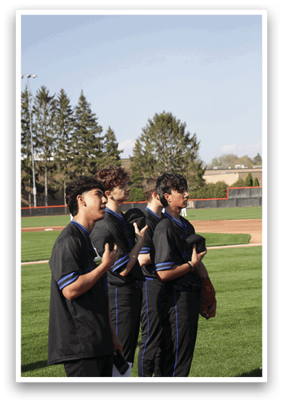 Four young men wearing black shirts and pants are standing on a grassy field. AI generated content