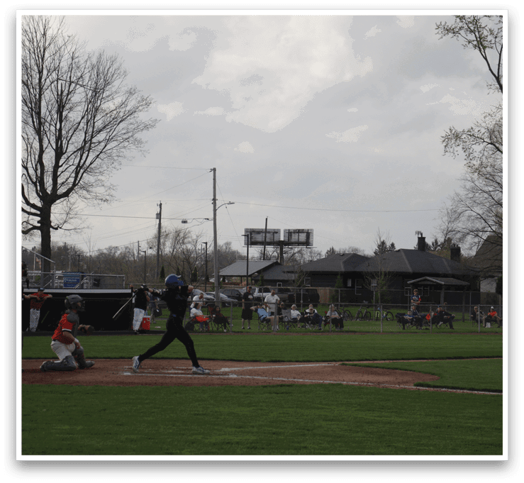 A baseball game is taking place with a batter swinging at a pitch. AI generated content