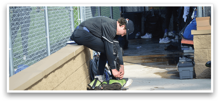 A person is sitting on a wall and putting on a shoe. AI generated content