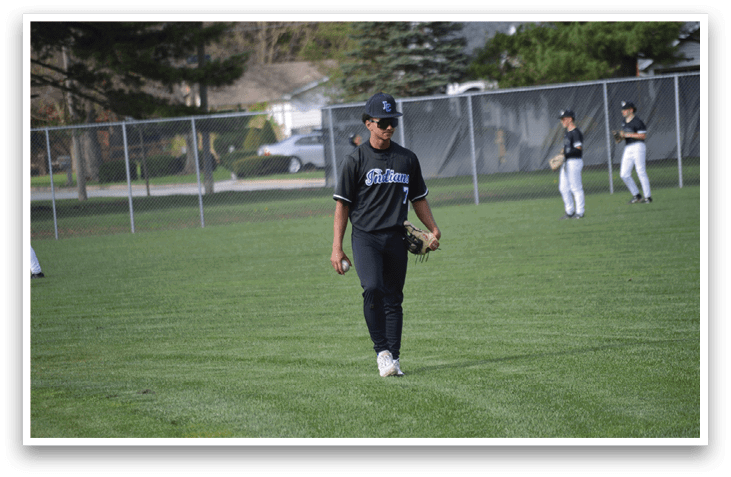 A man wearing a baseball uniform is walking across a grassy field. AI generated content