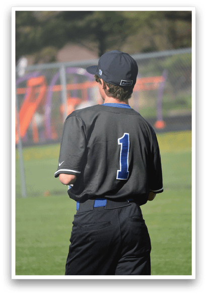 A baseball player wearing a black and grey uniform stands on a field. AI generated content
