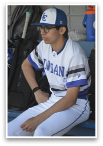 A baseball player wearing a white and blue jersey sits on a bench. AI generated content