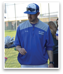 A group of baseball players wearing blue and white uniforms are standing on a field. One man is wearing a blue and white jacket and talking to another player. The players are holding baseball bats and gloves, indicating they are preparing for a game. AI generated content