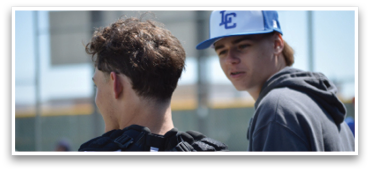 Two young men wearing baseball caps and jerseys are standing next to each other. AI generated content