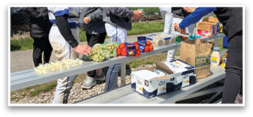 A group of people are gathered around a table with food and drinks. AI generated content