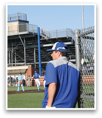 A man wearing a blue and white baseball uniform stands on a baseball field. AI generated content