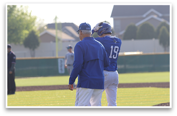 Two men in blue and white baseball uniforms are standing on a field, talking to each other. AI generated content
