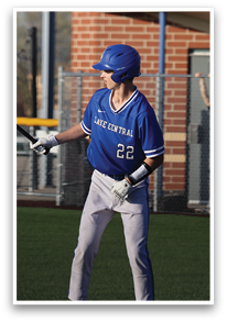 A baseball player in a blue shirt and white pants is holding a bat, ready to swing. AI generated content