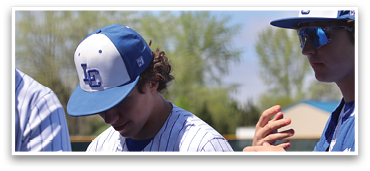 Two baseball players wearing blue and white uniforms are standing next to each other. One of the players is looking down at his glove, while the other is looking at something else. AI generated content
