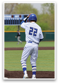 A baseball player in a blue and white uniform is standing on the field, holding his helmet. AI generated content