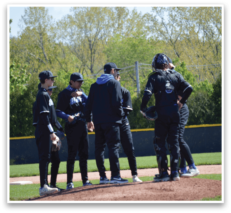 A group of baseball players standing on a field. Description generated by AI