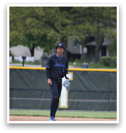 A baseball player in a black shirt and blue pants is running on the field. Description generated by AI