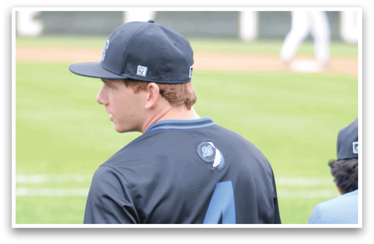 A baseball player wearing a black shirt with the number 4 on it. Description generated by AI