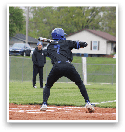 A baseball player in a black shirt and blue helmet is swinging a bat. Description generated by AI