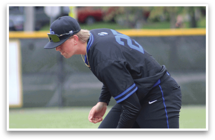 A baseball player wearing a black shirt and blue number 22. Description generated by AI