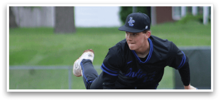 A baseball player in a black shirt and blue hat is pitching a ball. Description generated by AI