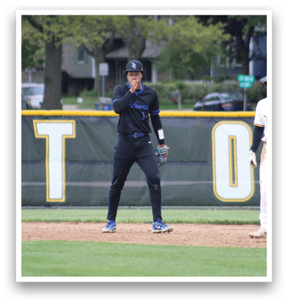 A baseball player in a black uniform is standing on the field. Description generated by AI