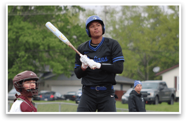 A baseball player holding a bat. Description generated by AI