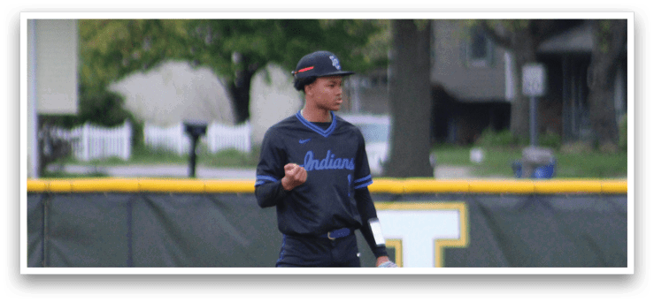 A baseball player wearing a black shirt and blue hat. Description generated by AI
