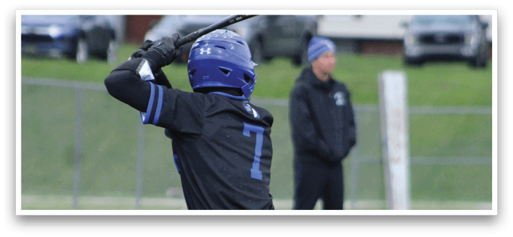 A baseball player in a black shirt and blue helmet is swinging a bat. Description generated by AI