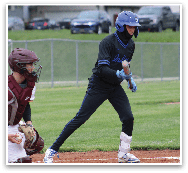 A baseball player in a black shirt and blue helmet is swinging a bat. Description generated by AI