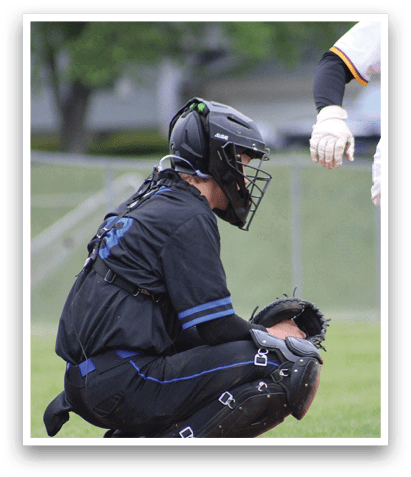 A baseball catcher kneeling on the ground. Description generated by AI