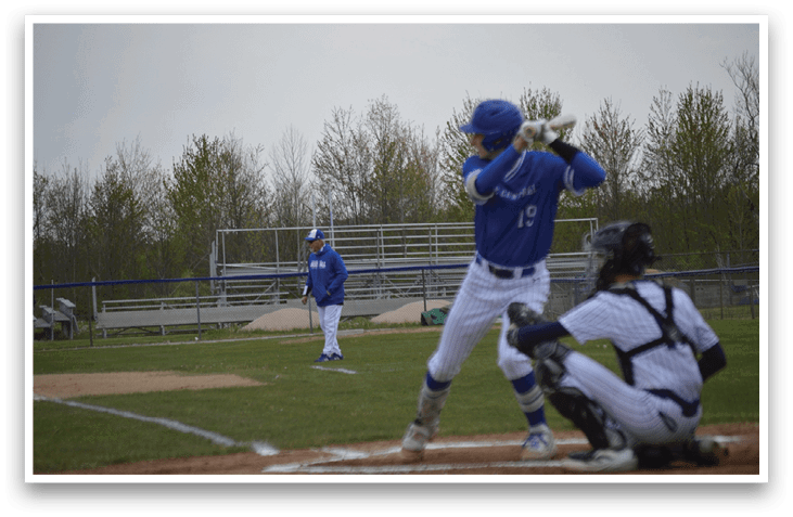 A baseball player in a blue and white uniform is swinging a bat. Description generated by AI