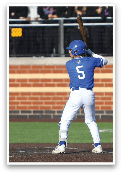 A baseball player is at bat, wearing a blue and white uniform. Description generated by AI