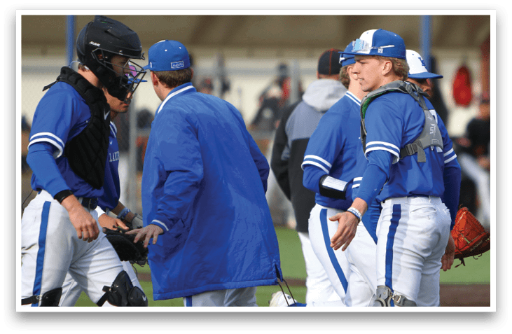 A group of baseball players wearing blue uniforms. Description generated by AI