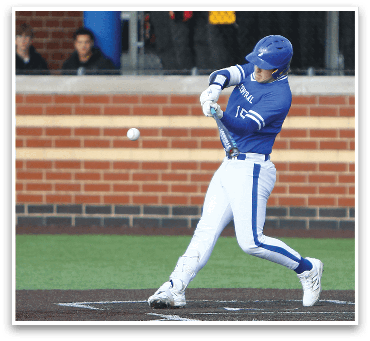 A baseball player in a blue and white uniform is swinging a bat at a ball. Description generated by AI