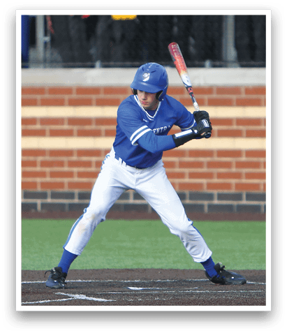 A baseball player in a blue and white uniform is swinging a bat at a ball. Description generated by AI