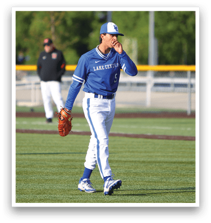 A baseball player wearing a blue and white uniform walks across the field. Description generated by AI
