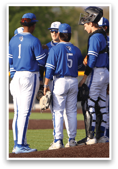 A group of baseball players wearing blue and white uniforms. Description generated by AI