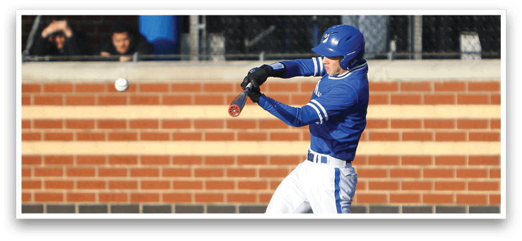 A baseball player in a blue and white uniform is swinging a bat at a ball. Description generated by AI