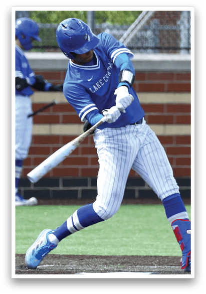 A baseball player in a blue and white uniform is swinging a bat at a ball. Description generated by AI