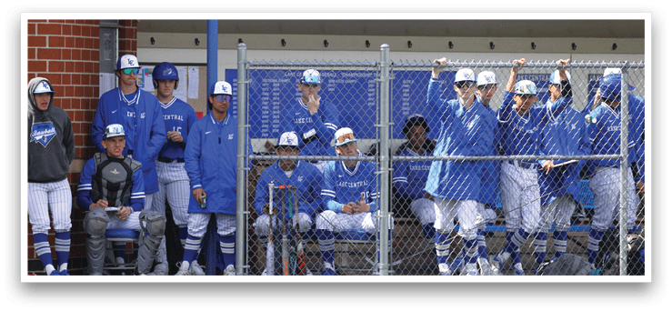 Baseball players in blue uniforms sitting on the bench. Description generated by AI