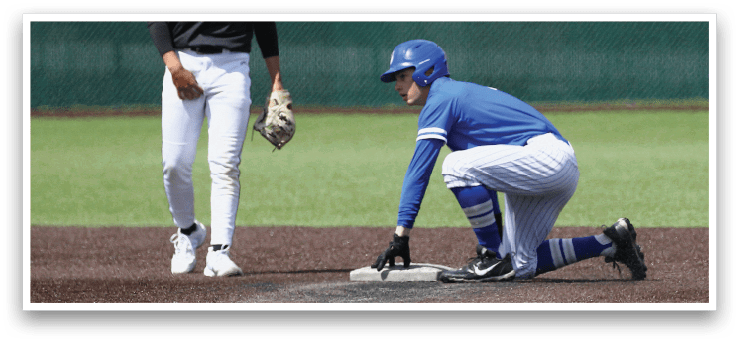 A baseball player is bending over to touch a base. Description generated by AI