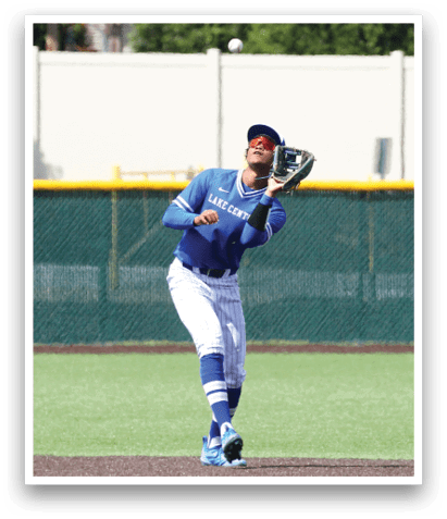 A baseball player wearing a blue and white uniform is catching a ball. Description generated by AI