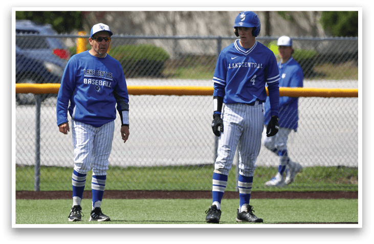 Two men wearing blue baseball uniforms. Description generated by AI