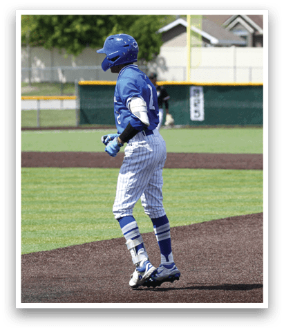 A baseball player wearing a blue and white uniform is walking on the field. Description generated by AI
