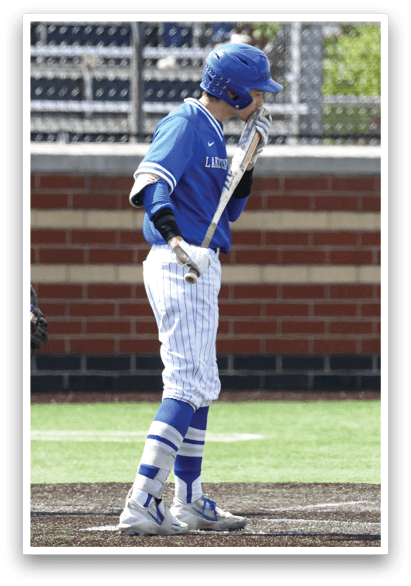 A baseball player with a blue helmet and blue and white uniform is standing on the field. Description generated by AI