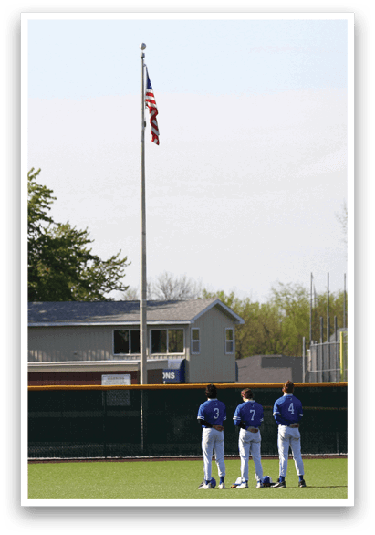 Three baseball players standing on a field. Description generated by AI
