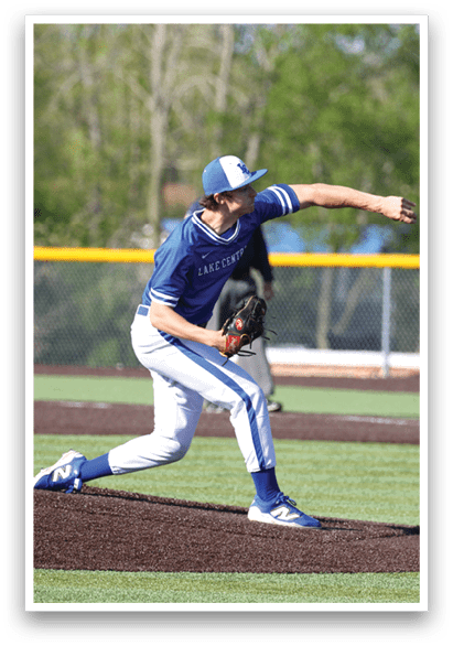 A baseball player in a blue and white uniform is pitching a ball. Description generated by AI