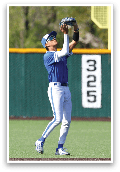 A baseball player wearing a blue and white uniform catching a ball. Description generated by AI