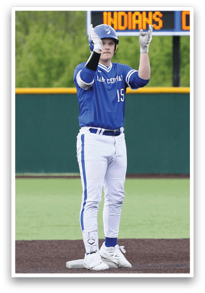 A baseball player wearing a blue and white uniform stands on the field. Description generated by AI